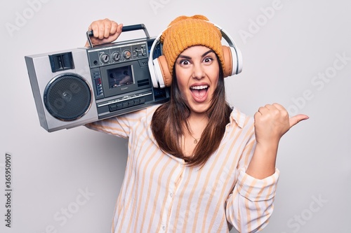 Konstfotografi Young beautiful brunette woman listening to music using vintage boombox and head