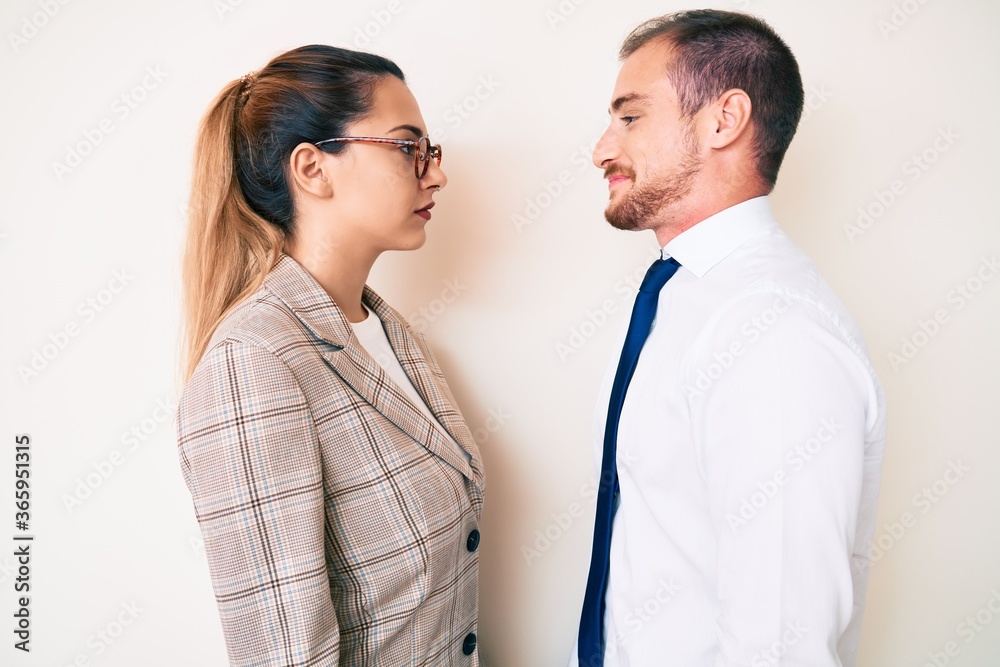 Beautiful couple wearing business clothes looking to side, relax profile pose with natural face and confident smile. Beautiful couple wearing business clothes looking to side, relax profile pose with natural face and confident smile.