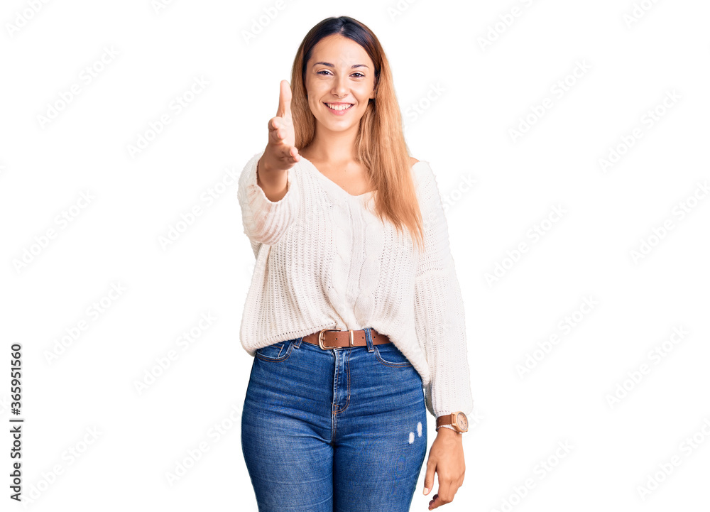 Beautiful young woman wearing casual clothes smiling friendly offering handshake as greeting and welcoming. successful business. Beautiful young woman wearing casual clothes smiling friendly offering handshake as greeting and welcoming. successful business.