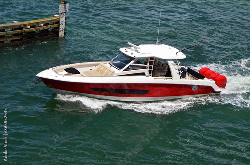 Red and white high-end motorboat cruising on the Florida Intra-Coastal Waterway
