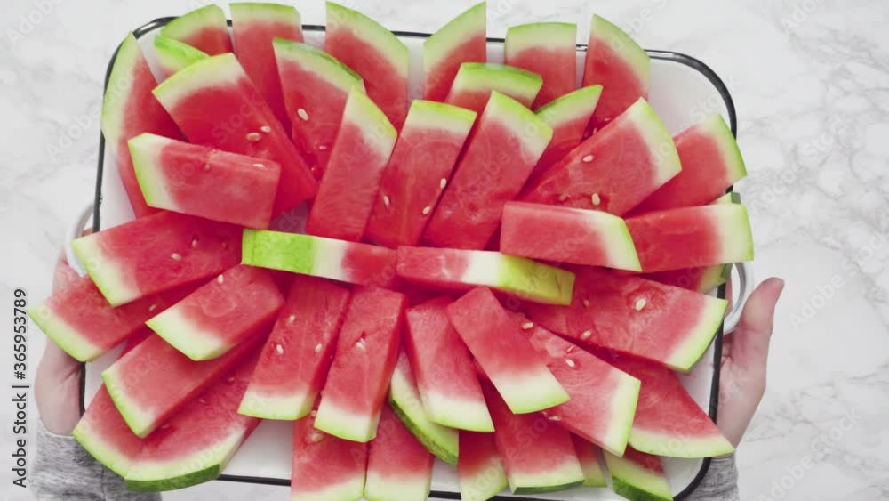 Flat lay. Small slices of red seedless watermelon on the tray for the party. Flat lay. Small slices of red seedless watermelon on the tray for the party.