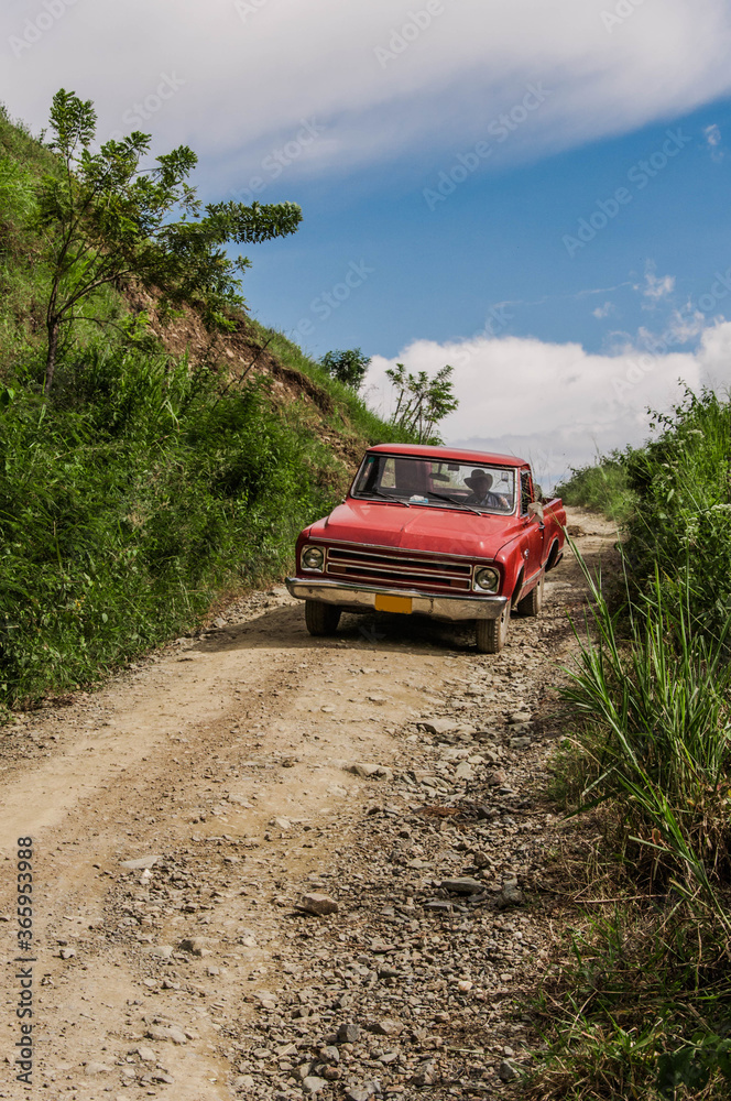 Old red van in an uncovered road near Medellin, Colombia