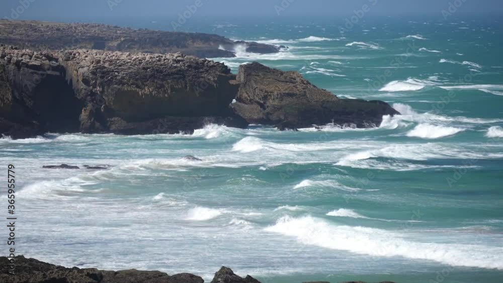 beach and cliffs with waves in a windy day slow motion