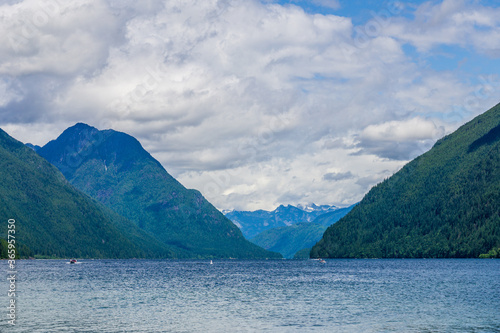 blue mountain lake with green mountains blue sky and white clouds © olegmayorov