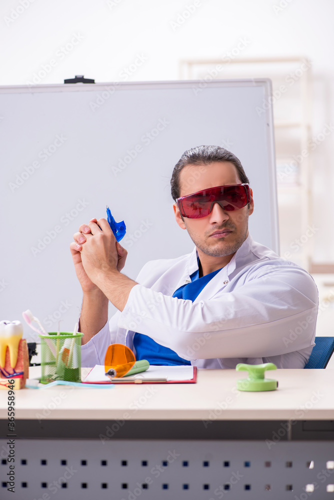 Young male dentist working in the clinic Young male dentist working in the clinic