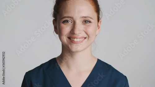 Young beautiful smiling nurse happily looking in camera over white background. Happy expression