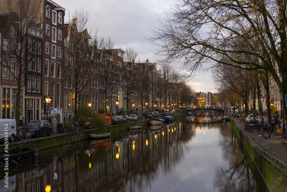 View of houses and Boats on Amsterdam Canal at morning light in Amsterdam, Netherlands
