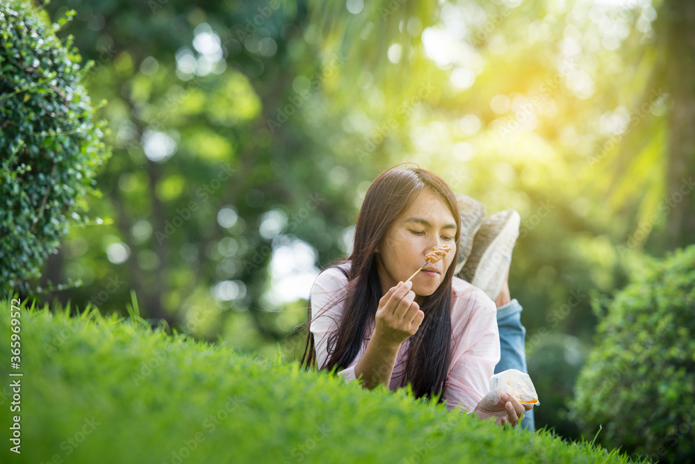 Relax beautiful asian woman smiling face Lying down on green grass field in outdoors garden park enjoy nature morning. Freedom Lifestyle woman breathing fresh air in green park on spring lawn outdoors Relax beautiful asian woman smiling face Lying down on green grass field in outdoors garden park enjoy nature morning. Freedom Lifestyle woman breathing fresh air in green park on spring lawn outdoors