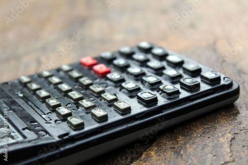 a wet scientific calculator isolated on stone background