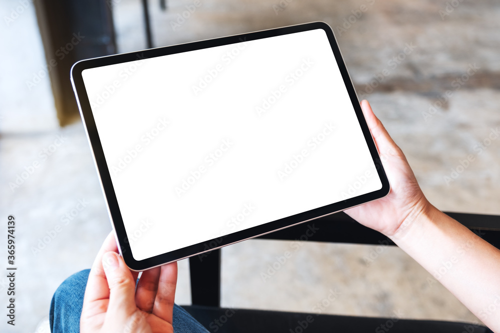 Mockup image of a woman holding black tablet pc with blank white desktop screen Mockup image of a woman holding black tablet pc with blank white desktop screen