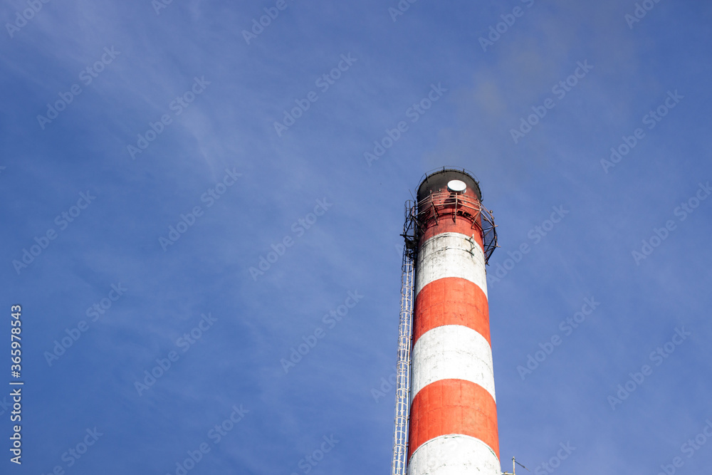 Red and white brick industrial pipe against the blue sky.4