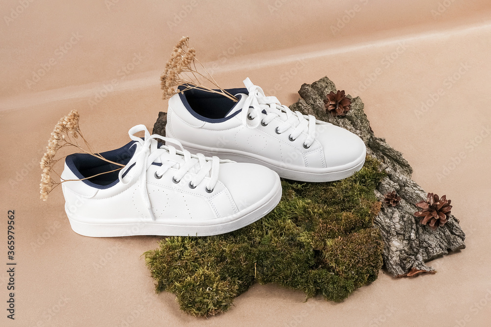 Ethical vegan shoes concept. A pair of white sneakers with dry flowers on  tree bark and moss, neutral beige craft paper background Stock Photo |  Adobe Stock