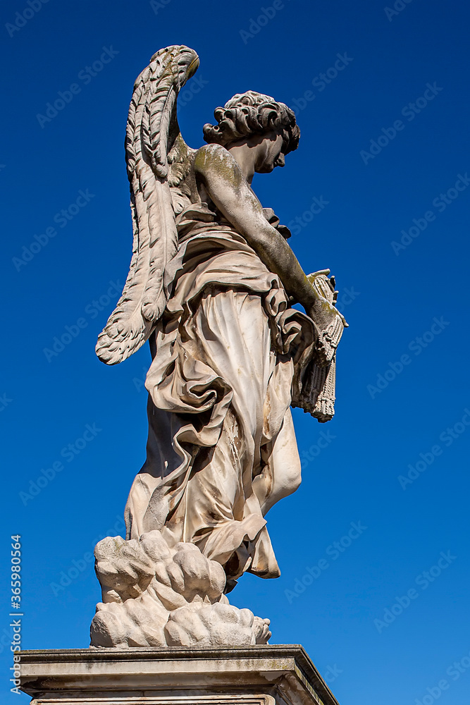 Statue of a monument to an angel on a background of blue sky.