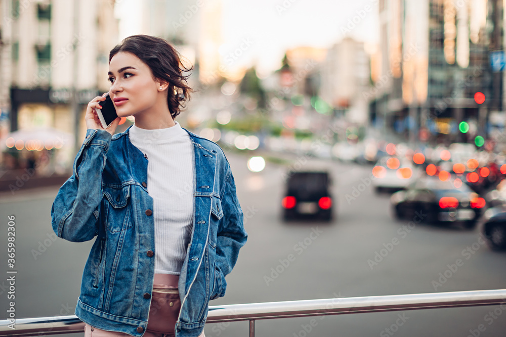Young woman talking on phone on street