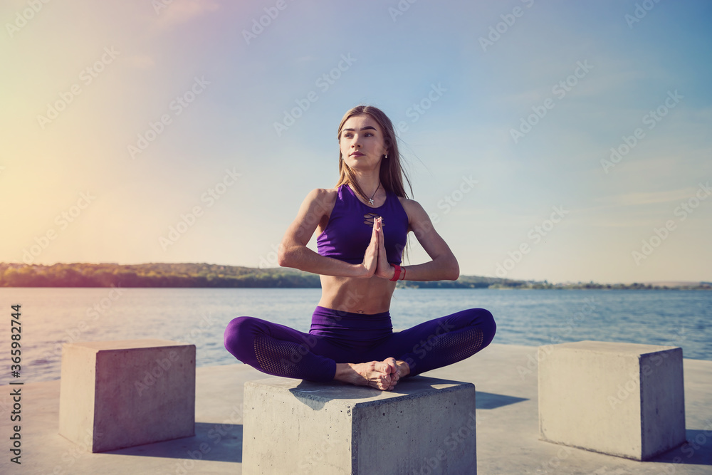 Young brunette woman  practicing yoga early morning before working time.  Concept of wellness and healthy lifestyle.
