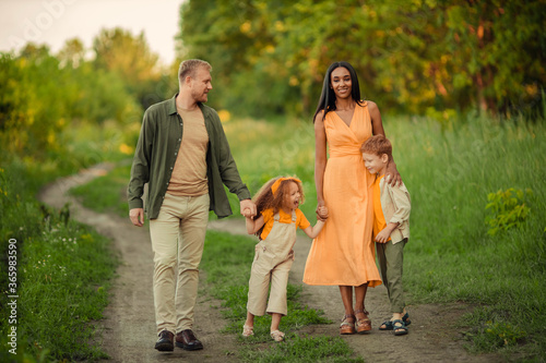 Happy international family on a summer walk in the park.