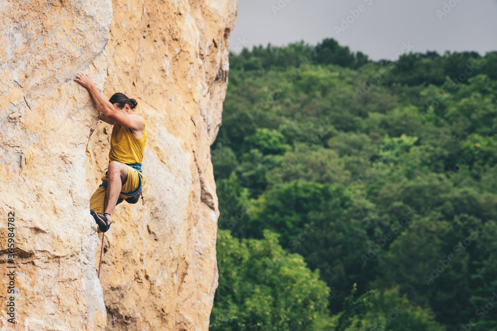 Obraz premium Man climbs a rock.