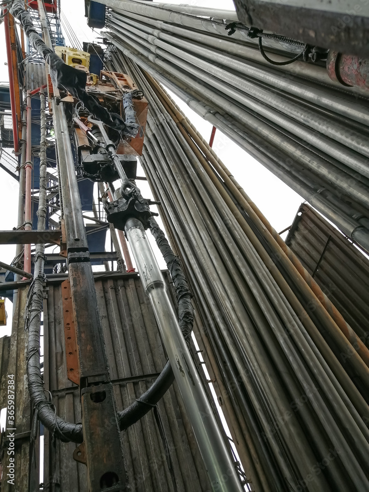 The internal structure of the drilling rig. Top power drive of drilling rig, equipment for lowering and lifting pipes. Drill pipes installed vertically.
