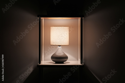 Fototapeta Naklejka Na Ścianę i Meble -  Glowing lamp on shelf in evening