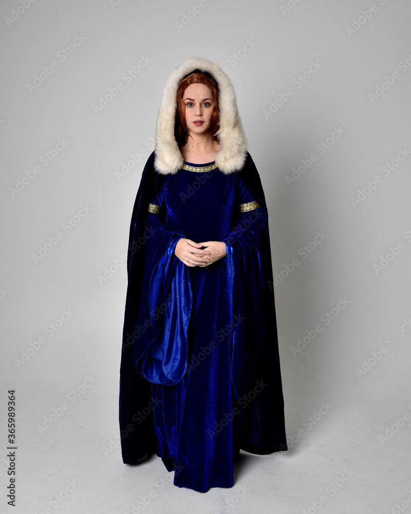 Full length portrait of girl wearing long blue velvet gown with golden ...