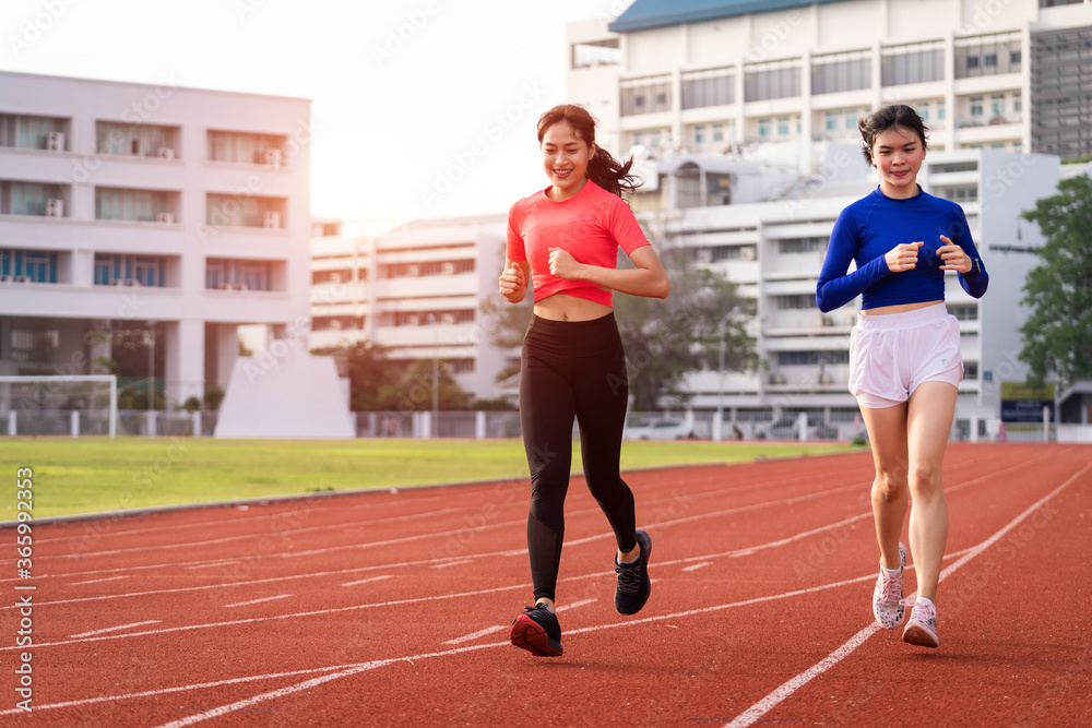 Fototapeta premium Young fitness woman runner jogging excercise in the morning on city stadium track in the city. Female athlete excercise in the city stadium to keep body fitness. Stock photo.