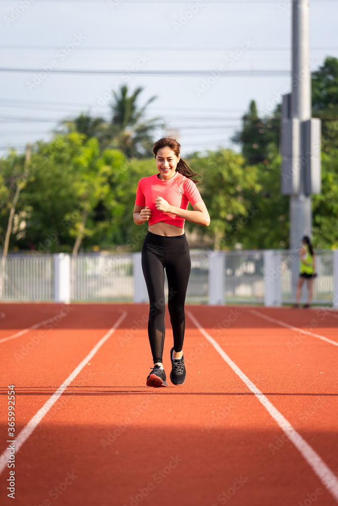 A young fitness woman runner jogging excercise in the morning on city stadium track in the city. Female athlete excercise in the city stadium to keep body fitness. Health and recreation stock photo. A young fitness woman runner jogging excercise in the morning on city stadium track in the city. Female athlete excercise in the city stadium to keep body fitness. Health and recreation stock photo.