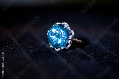 macro shot of a white precious metal ring with big blue gem