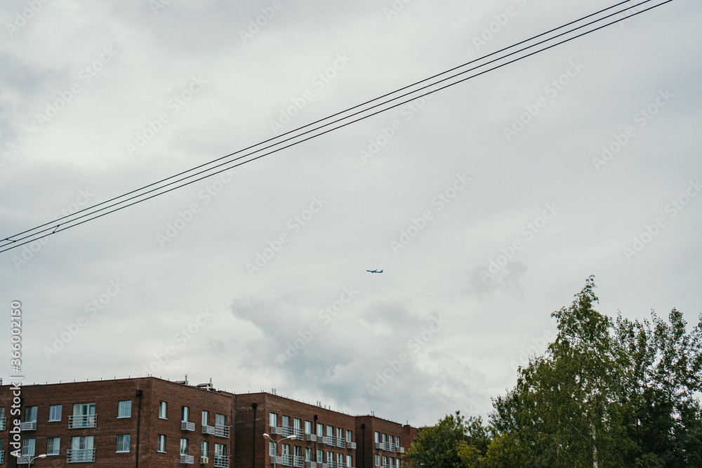 plane in the sky over a residential building plane in the sky over a residential building