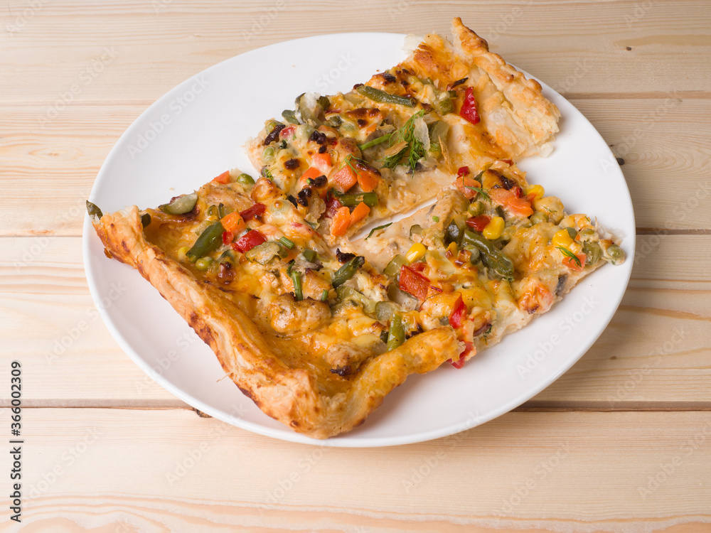 Homemade delicious pizza. The pieces are on a round white plate. Traditional cuisine Homemade delicious pizza. The pieces are on a round white plate. Traditional cuisine