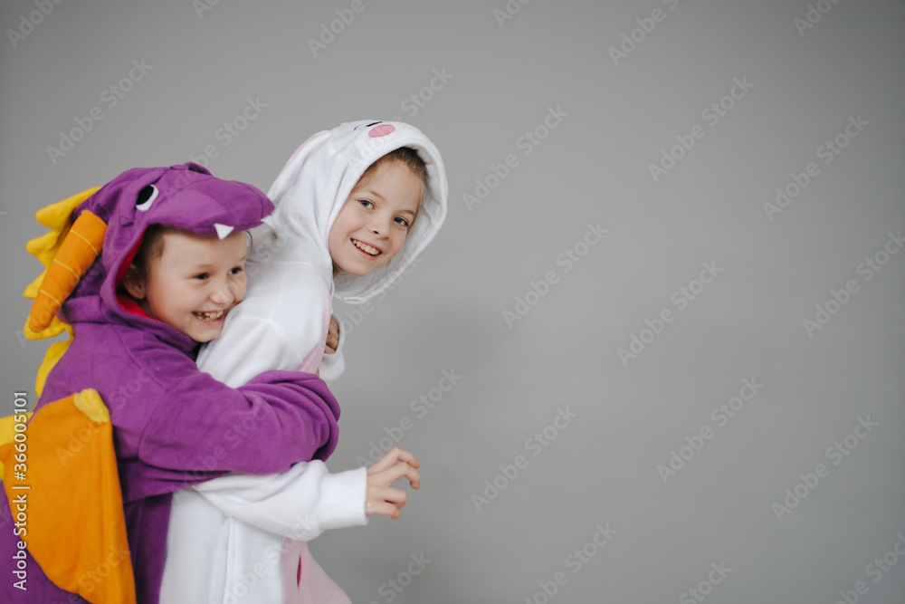 two beautiful girls dressed as rabbit and dragon posing in front of grey background two beautiful girls dressed as rabbit and dragon posing in front of grey background