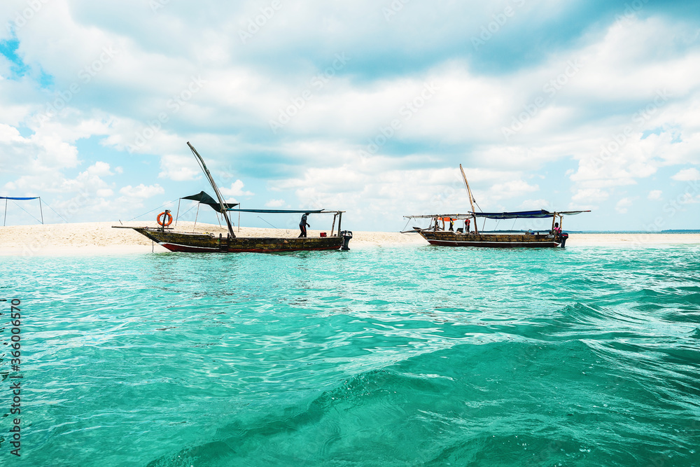 Sand bank with two boats in ocean in Zanzibar