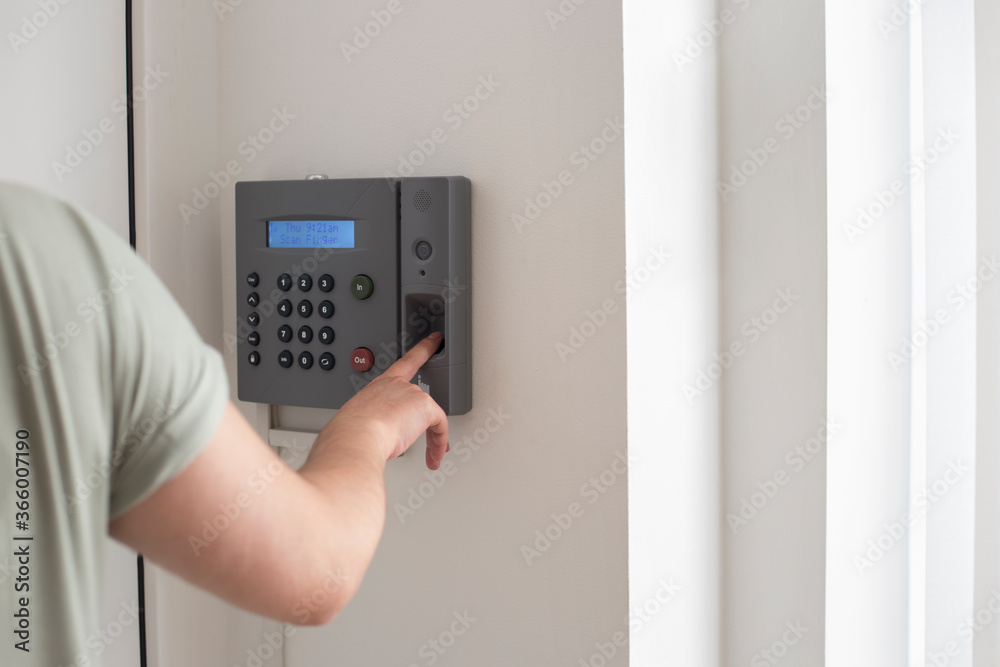 Side view of hand scanning fingerprint to screening system gain entry security to building. Biometric locks control access to record working time Side view of hand scanning fingerprint to screening system gain entry security to building. Biometric locks control access to record working time
