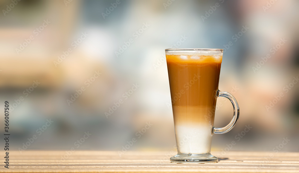 Closeup one glass with ice latte on wooden table. Selective focus Closeup one glass with ice latte on wooden table. Selective focus