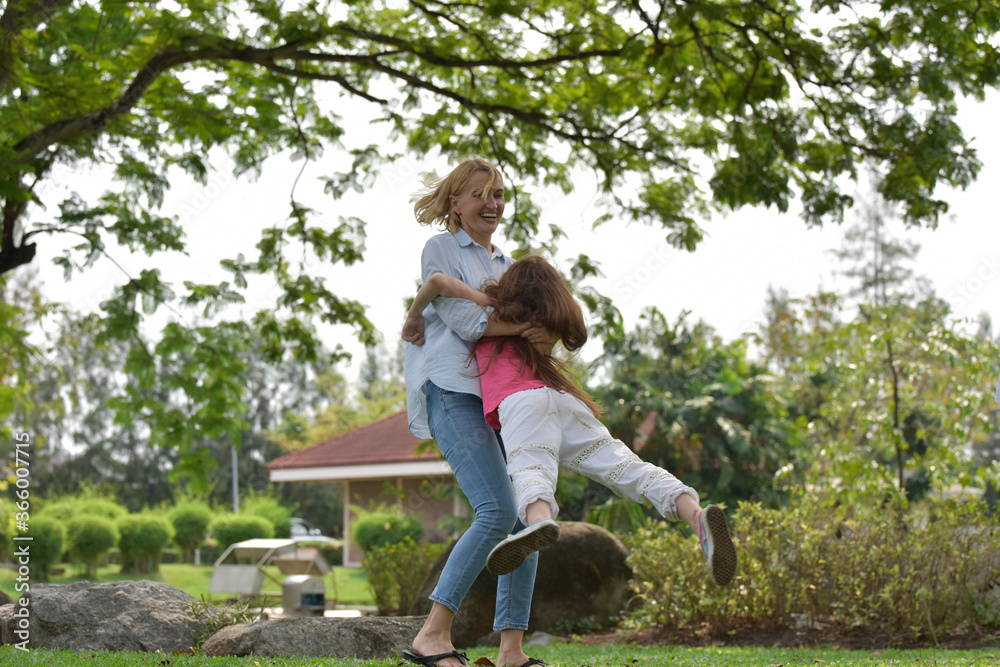 Naklejka premium happy family of mother and daughter in park . Family and Insurance concept.