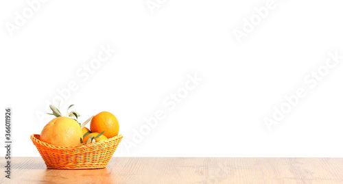 Fototapeta Naklejka Na Ścianę i Meble -  Basket with fresh fruits on kitchen table against white background