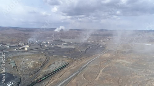Aerial view of copper plant in Karabash city. Around the contaminated area. Smoke comes out of the chimney and flies into the camera. Cars drive on the road. Russia, Chelyabinsk region
