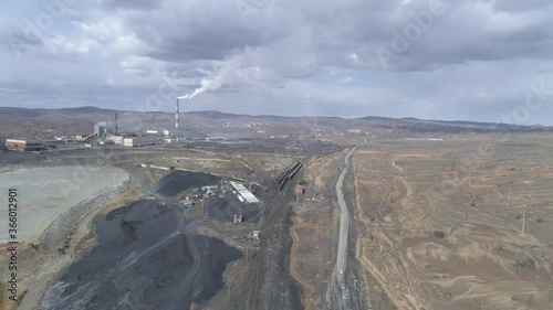 Aerial view of copper plant in Karabash city. Smoke comes out of the chimney. Around the contaminated area. Cars drive on the road. Russia, Chelyabinsk region