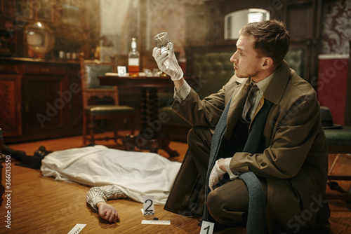 Male detective looking evidence at the crime scene