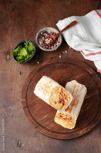 Obraz na płótnie A cut Chicken doner kebab in roll of pita bread lavash. Shawarma Sandwich on a wooden background w salonie