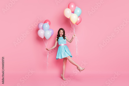 Full length body size view of her she nice attractive lovely fashionable smart cheerful cheery wavy-haired girl having fun holding in hand helium balls dancing isolated on pink pastel color background