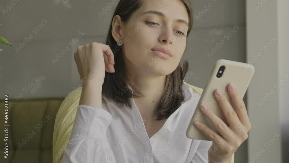 Young amazing concentrated woman indoors at home using mobile phone Young amazing concentrated woman indoors at home using mobile phone