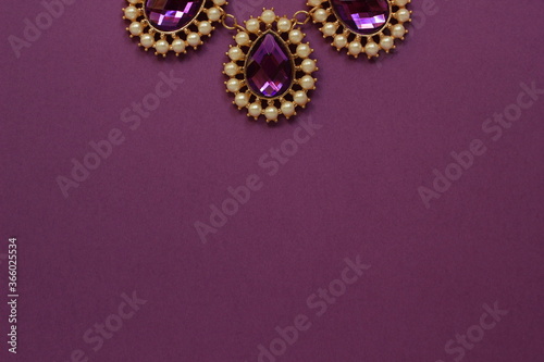 luxury purple jewelry in the Baroque style on a purple background. Vintage, retro style. copy space 