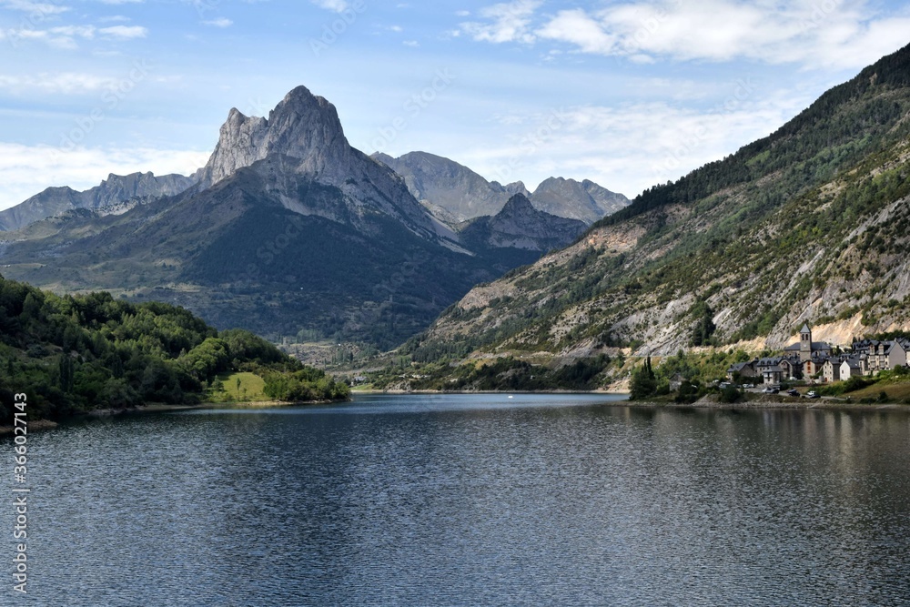view of a reservoir in summer in front of a mountain peak