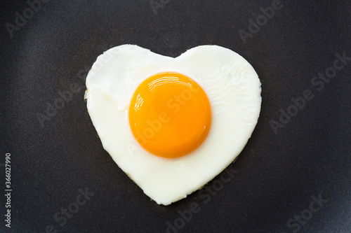Fried egg in the shape of a heart in a pan