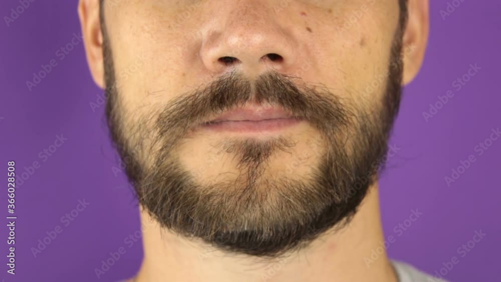 Handsome young guy trims his beard with scissors. Handsome young guy trims his beard with scissors.