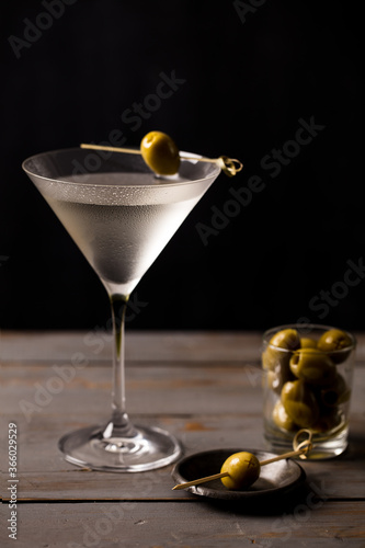 Martini with olives. On a wooden background