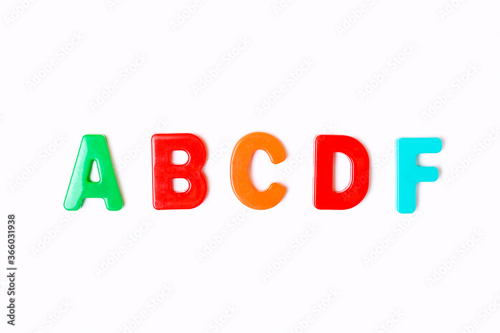 School grades from multi-colored letters on a white background. A, B, C, D, F. Concept of learning and education. The concept of grades for academic success. Top view, minimalism, flat lay. School grades from multi-colored letters on a white background. A, B, C, D, F. Concept of learning and education. The concept of grades for academic success. Top view, minimalism, flat lay.