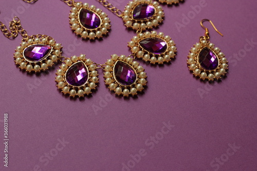 luxury purple jewelry in the Baroque style on a purple background. Vintage, retro style. copy space 