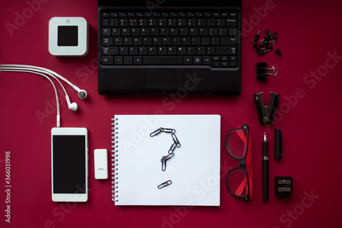 Red office desk top view with stationery, computer accessories and noteboo with question. Corporate stationery branding. Bussines idea concept. photo