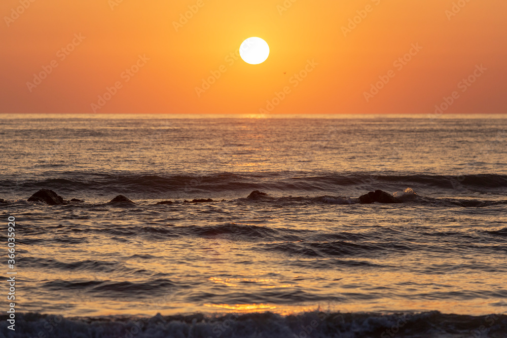The sun rises over the mediterranean sea on a clear sky morning